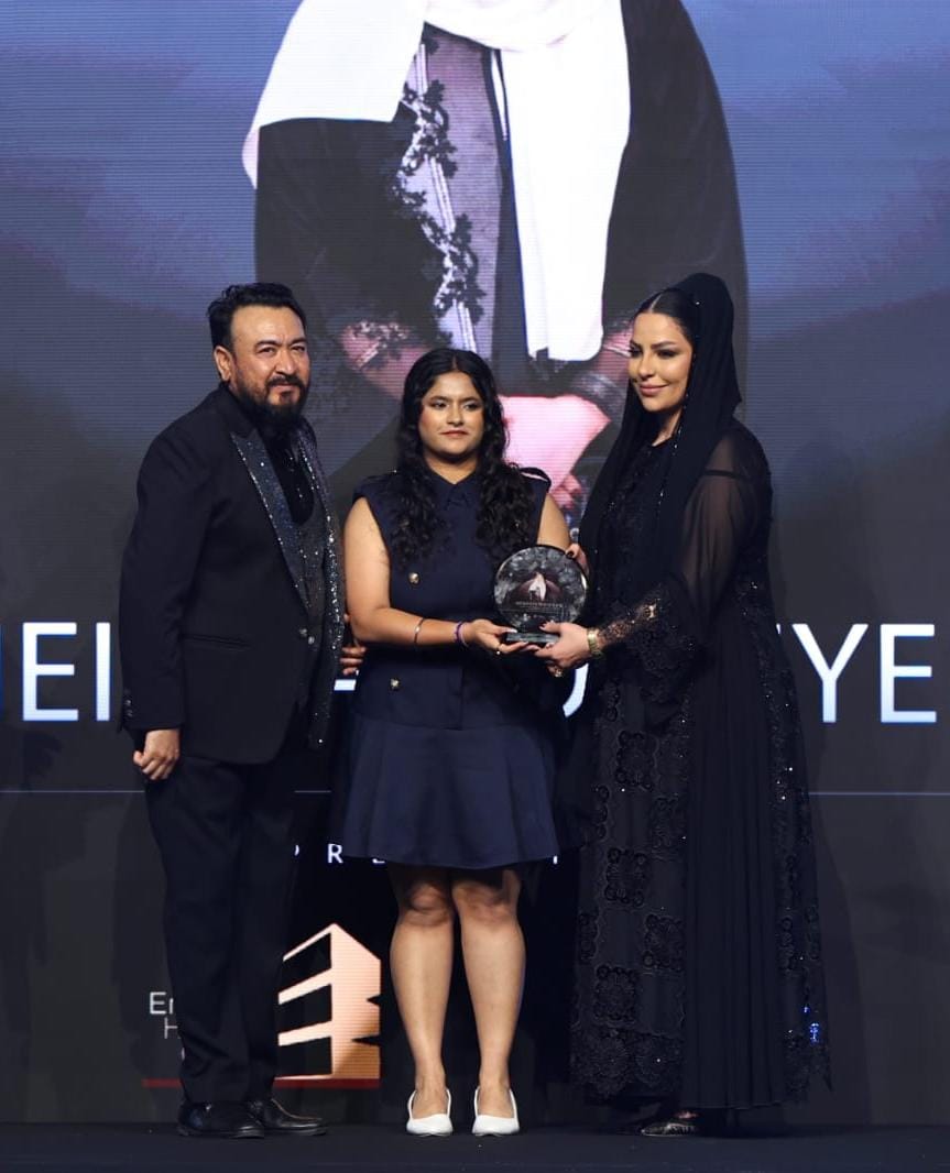 Three participants holding an award on stage at Emirates Luxury Show
