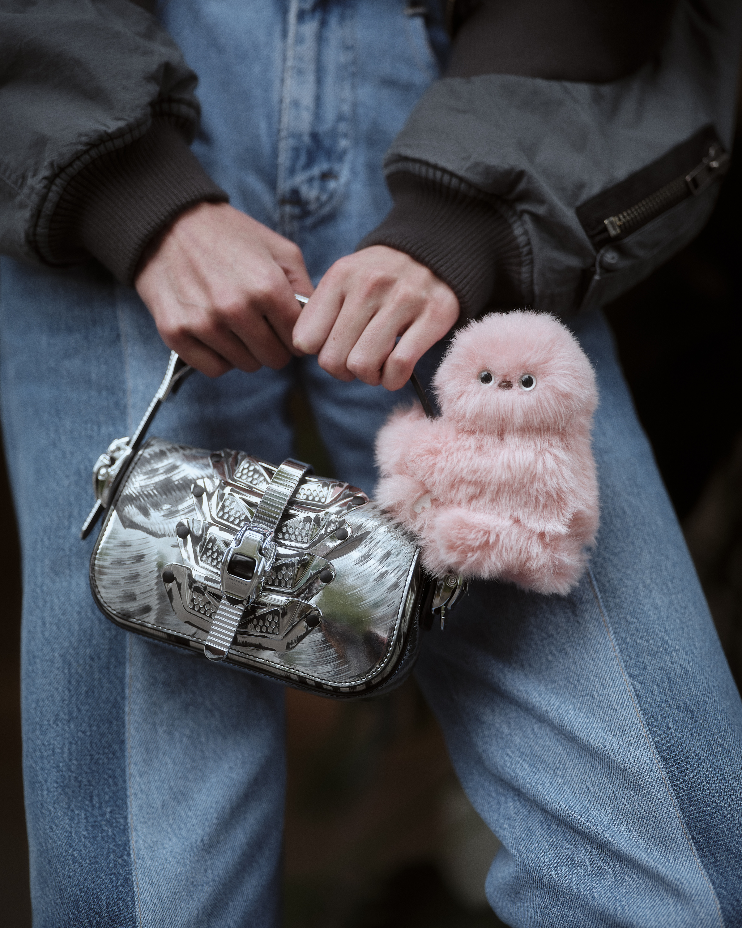 Pink Mirumi robot companion attached to a silver handbag