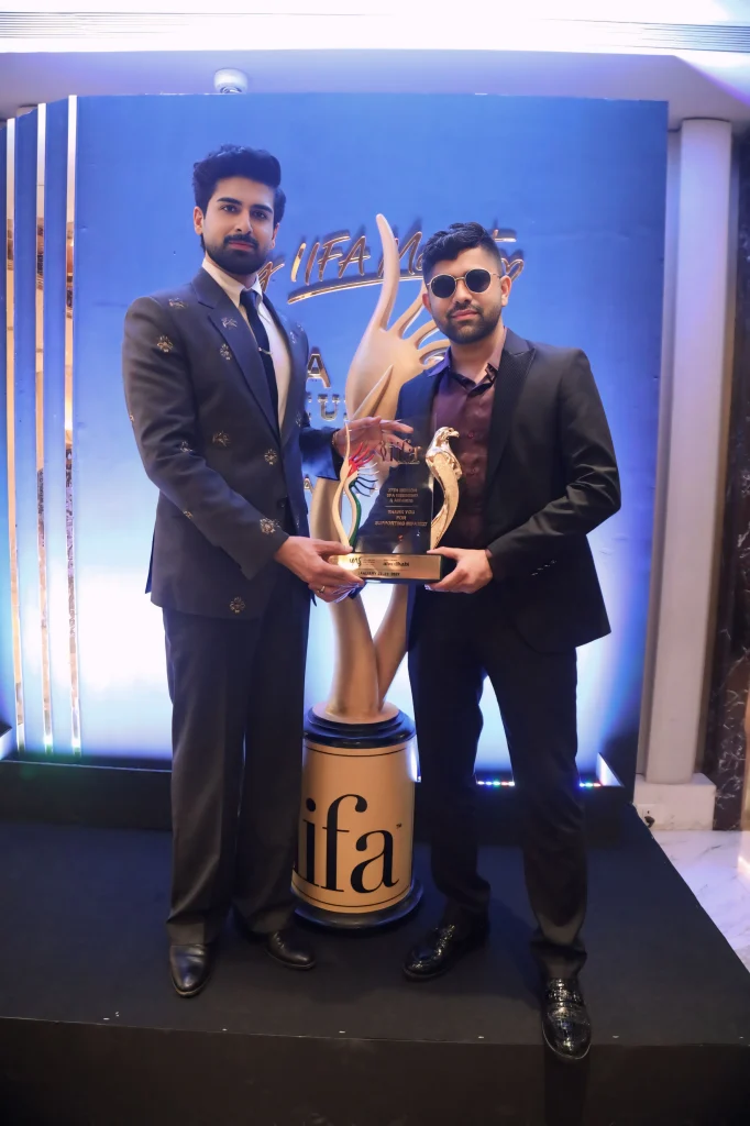 Bilal Kazi posing with a guest and an IIFA trophy