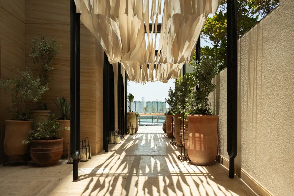 Sunlit passage leading towards the waterfront at Avli by tashas Bahrain