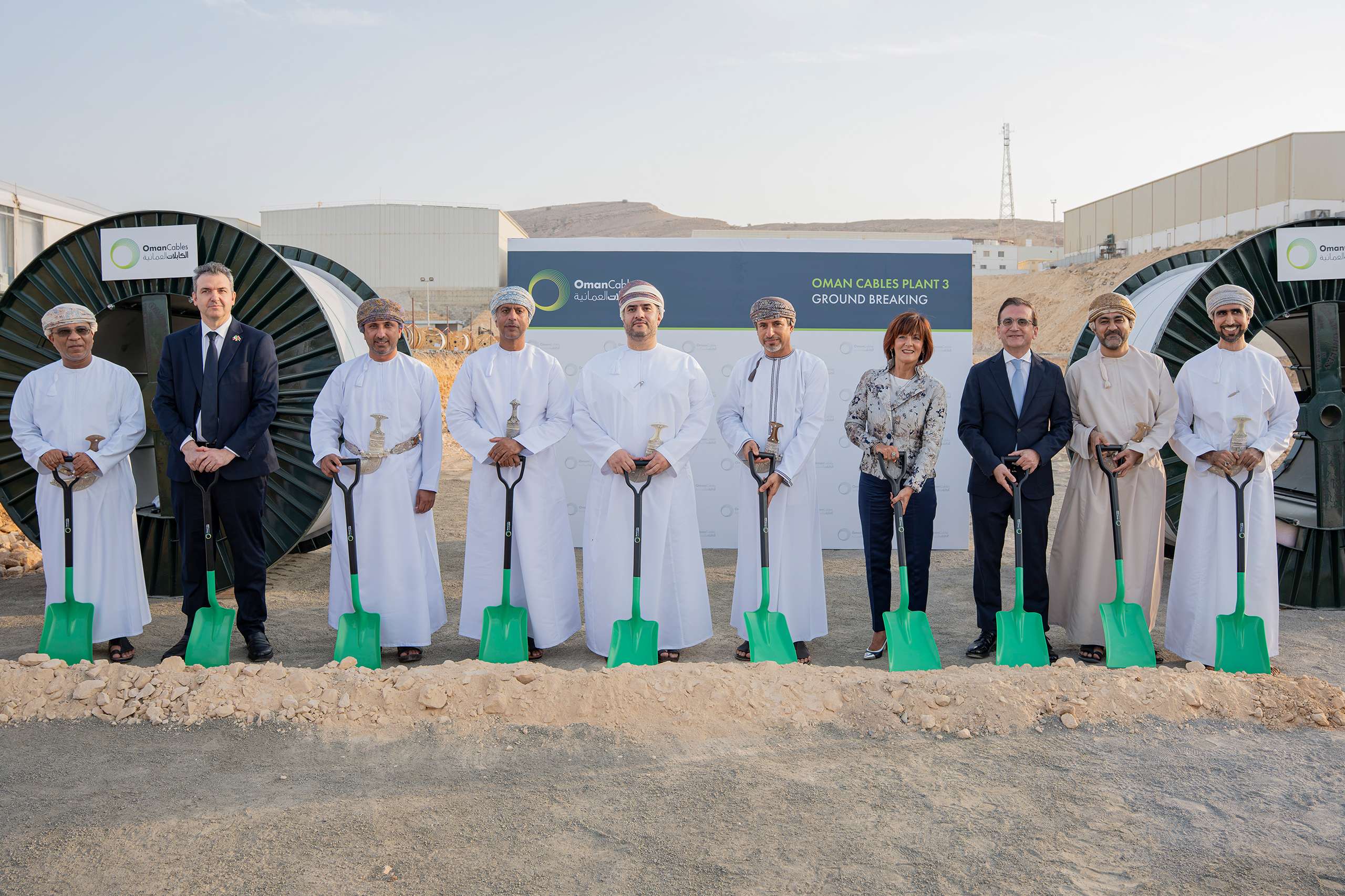 Guests holding green shovels at the Oman Cables Plant 3 groundbreaking ceremony in Rusayl