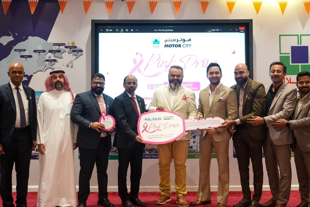 Representatives mark the Pink Drive partnership with a ceremonial key